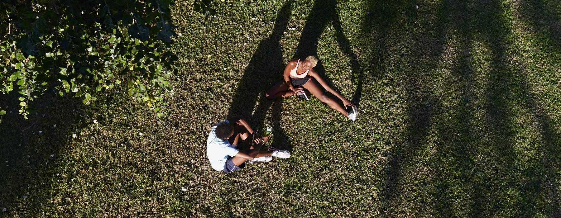 a woman and a man sitting in a grassy area